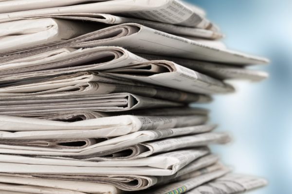 Pile of newspapers on white background